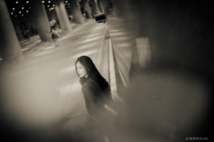 一位年轻女子在夜晚穿黑白色走在街上