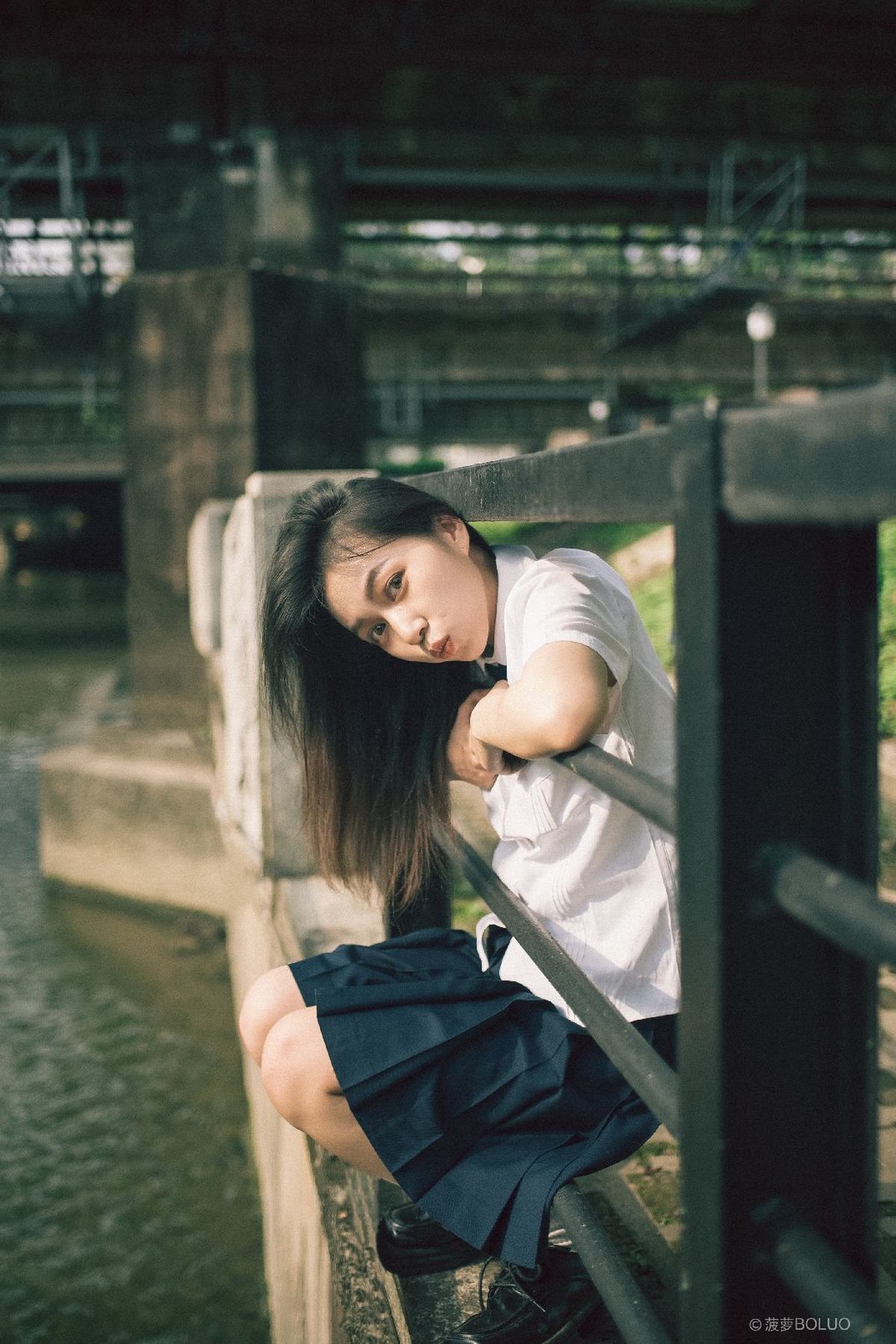 一位年轻女子坐在水上的桥上