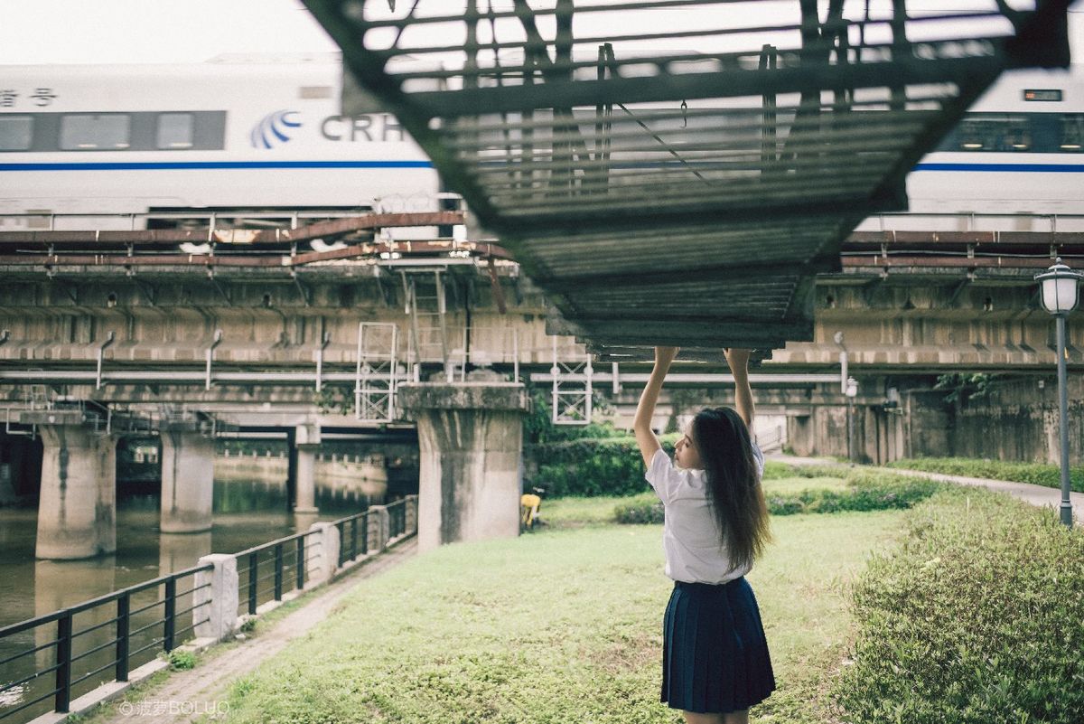 站在河上的桥上 火车从桥上经过的年轻女子