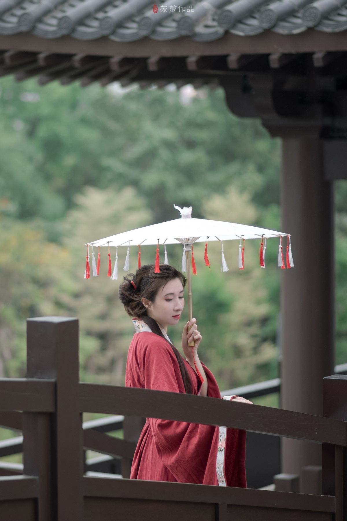 一位穿着红色和服的年轻女子手持白色雨伞