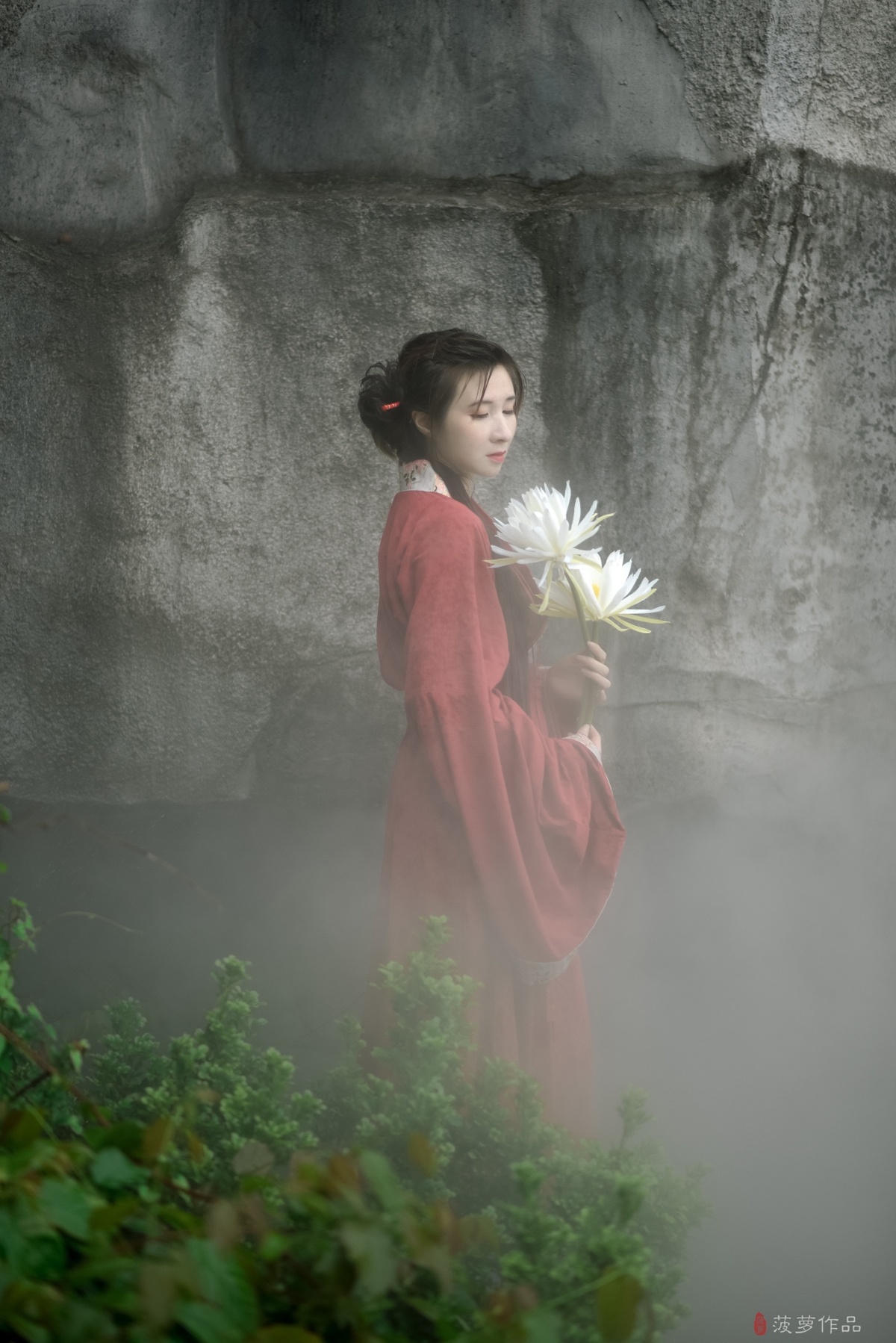 一位穿着红裙子的年轻女子手里拿着白花