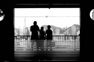 一个人和一个女人站在一扇窗户前 眺望着城市。