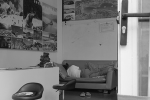 一张黑白照片 展示了一个客厅 里面有人躺在沙发上 还有一个人躺在椅子上。