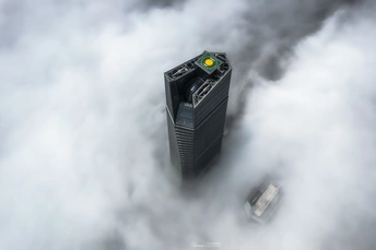 雾气缭绕的高塔在阴天云层中的照片