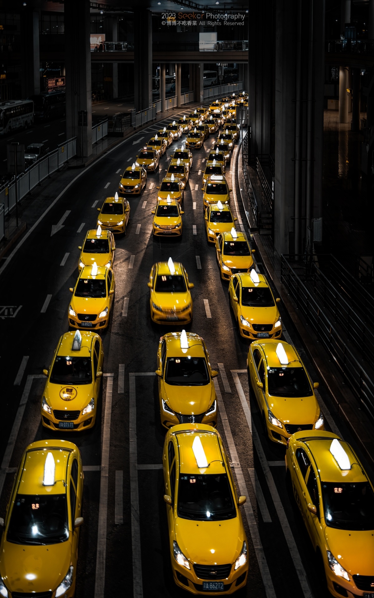 许多黄色出租车排成一排 夜晚在街上。