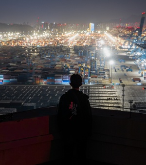 一个站在建筑物屋顶上 晚上看着城市的男人