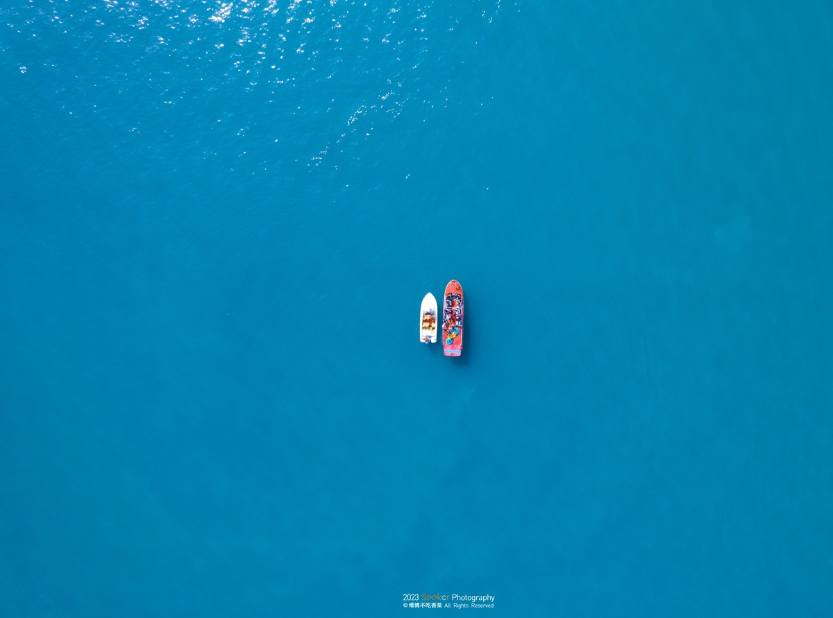 aerial view of a small boat with people floating o