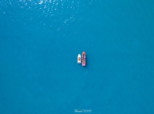 aerial view of a small boat with people floating o