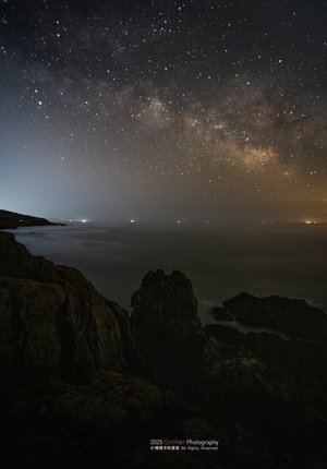 夜晚的岩石海岸 海洋和星空在天空中。