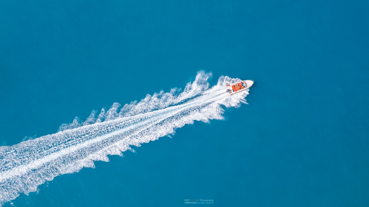 一架飞机在海洋上空飞越一艘小船