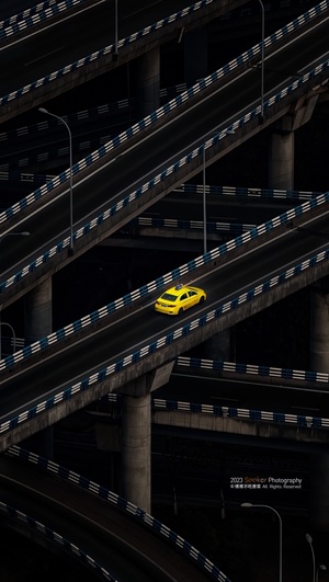 一辆黄色汽车驶过一座天桥