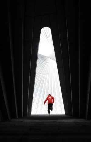 一个穿红衬衫的男人在高层建筑内奔跑 窗户透出光线