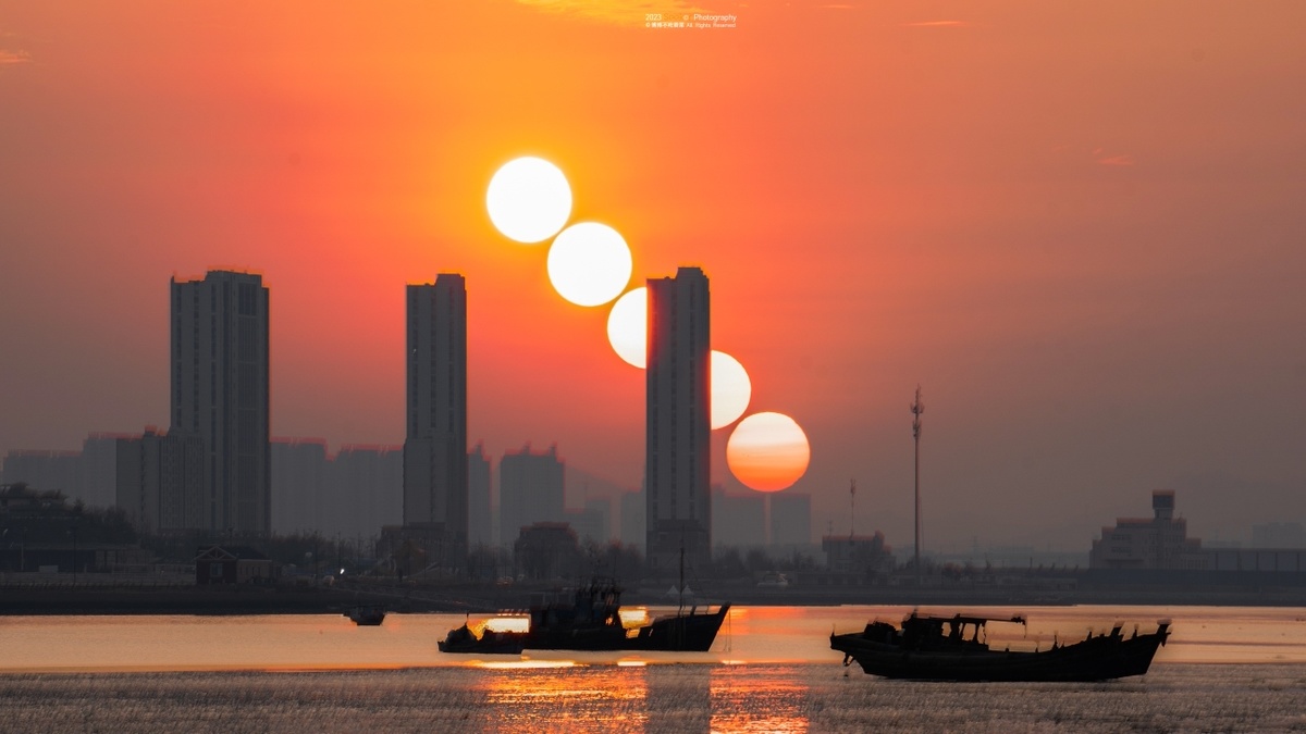 城市上空的落日 太阳升起时 水中有小船。