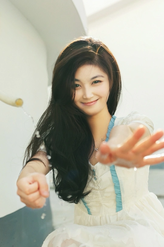 一位身穿白色连衣裙、双手伸出的年轻女子