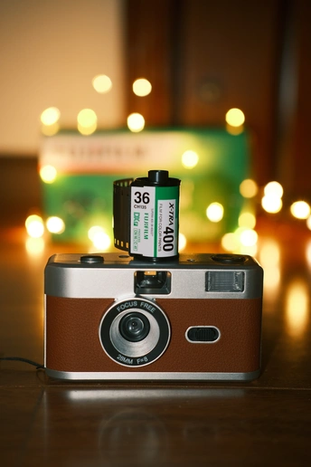 在圣诞树前的木制桌子上的相机