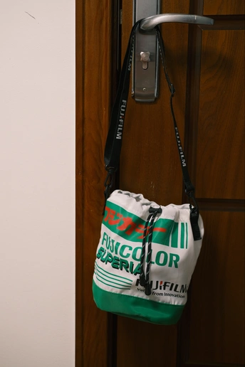 一只绿色的袋子挂在电话旁边墙上