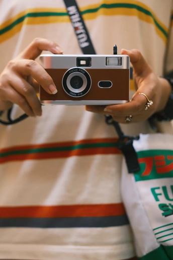 一位年轻女子手持相机拍照