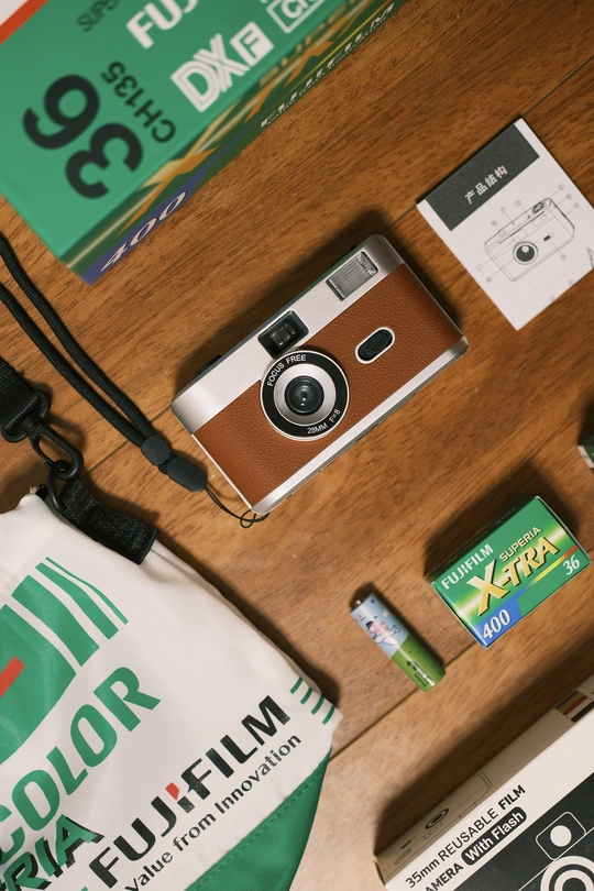 一个木制桌子顶部放着一个包和一个相机