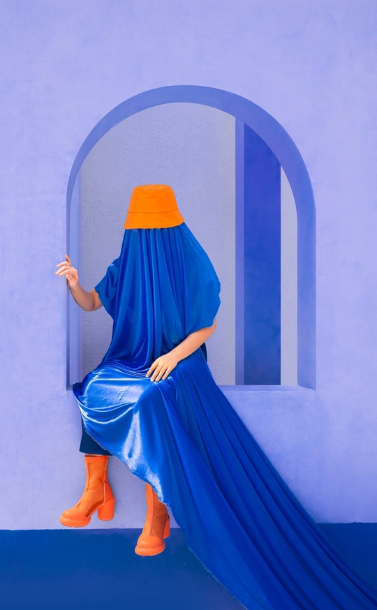 一位穿着蓝色连衣裙、橙色靴子和头戴披肩的女士