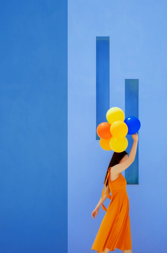 一位穿着橙色连衣裙的年轻女子 holding colorful balloons
