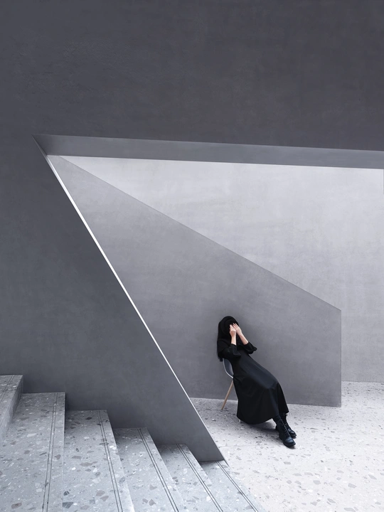 一位穿着黑色连衣裙的女人在混凝土楼梯上