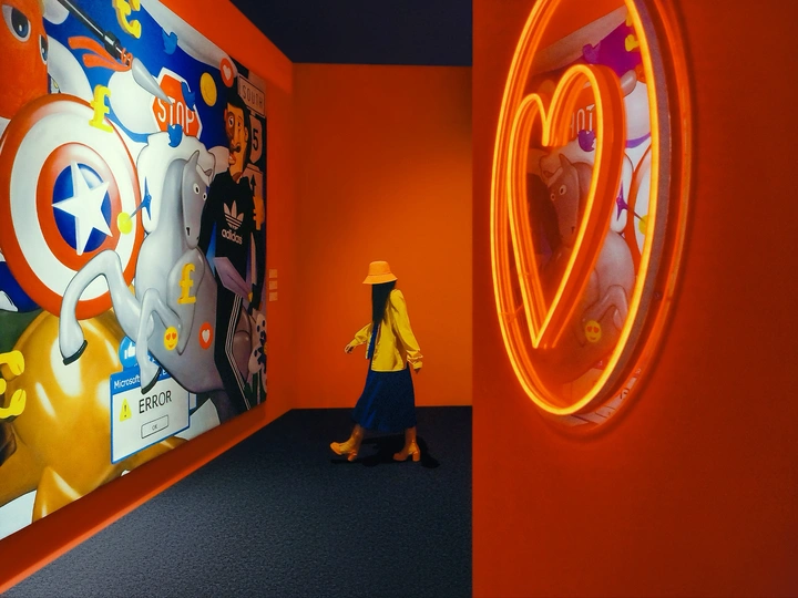 一张照片 一个人穿过挂满画作的房间