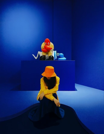 一只穿着黄帽子的鸭子雕塑 sits 在一个蓝色的房间中间