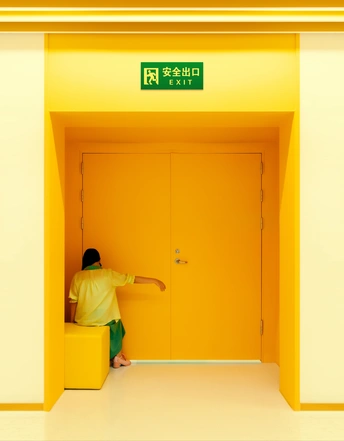 一个人站在一个带黄色门的房间里