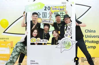 一个人在一场活动前照相 背景板上有一个广告。