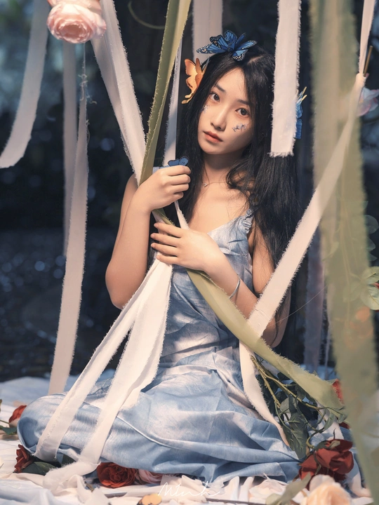 一位穿着蓝色连衣裙 头戴花的女青年