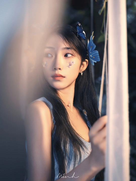 一位长着蓝眼睛 头戴鲜花的年轻女子正对着镜子看。