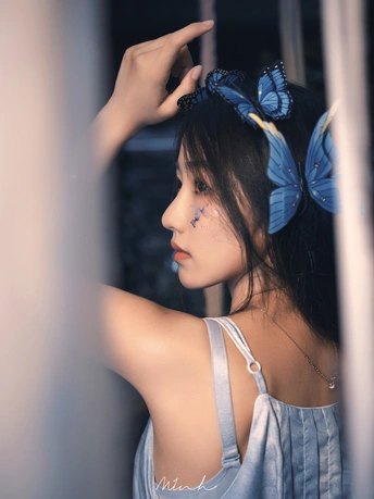 一位戴蓝蝴蝶结的年轻女子正对着镜子看。