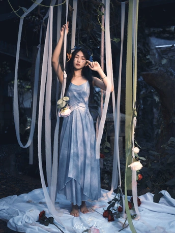 一个穿着蓝色连衣裙的年轻女子站在一个铁丝笼子里