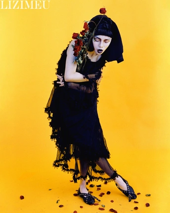 穿黑色连衣裙 胸前有红玫瑰的女人