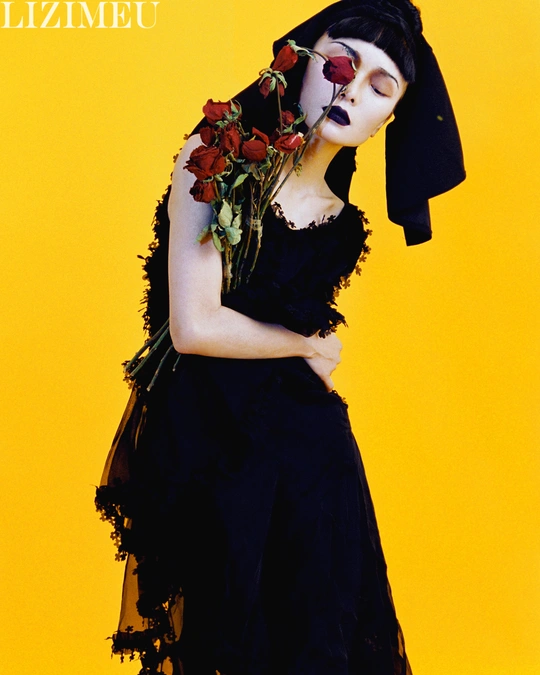 一位穿着黑白服装的女士 holding红玫瑰