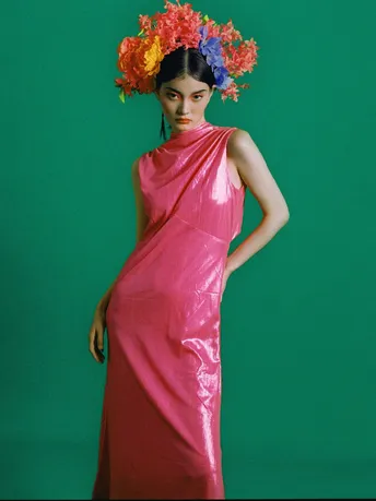 一位穿着粉红色连衣裙 头戴红花的模特