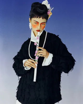 一个穿黑色连衣裙的女孩拿着长笛