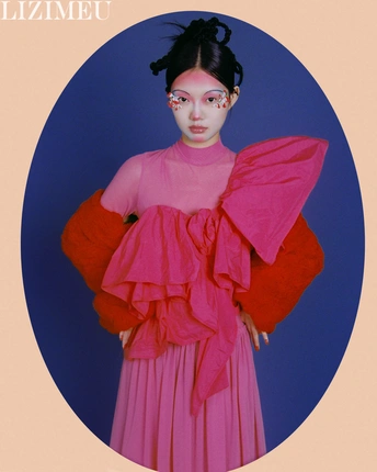 一位穿着粉红色连衣裙的模特 背景是蓝色。