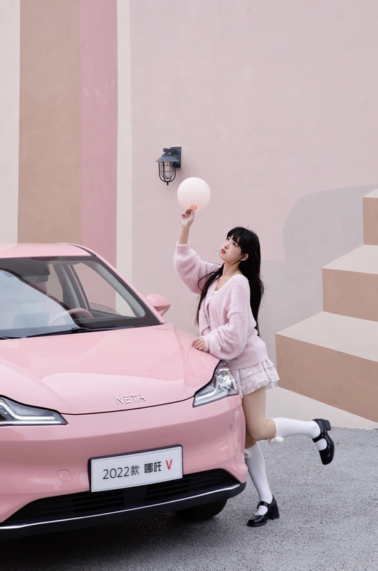 一位年轻女子抓住一辆粉色汽车