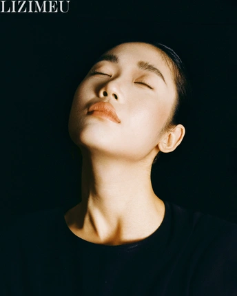 一位年轻女子闭着眼睛 头部向一侧倾斜 仿佛在仰望天空中的光线。