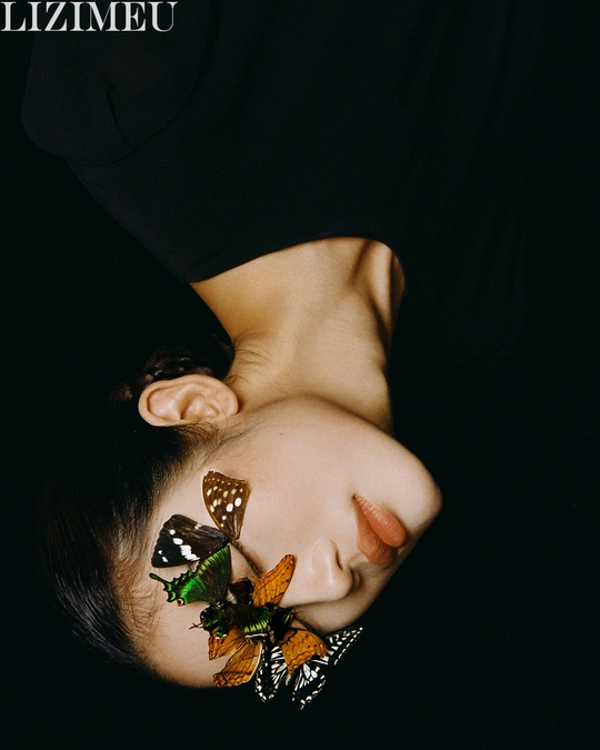 一位女子将脸埋在枕头上 头上有一只蝴蝶。