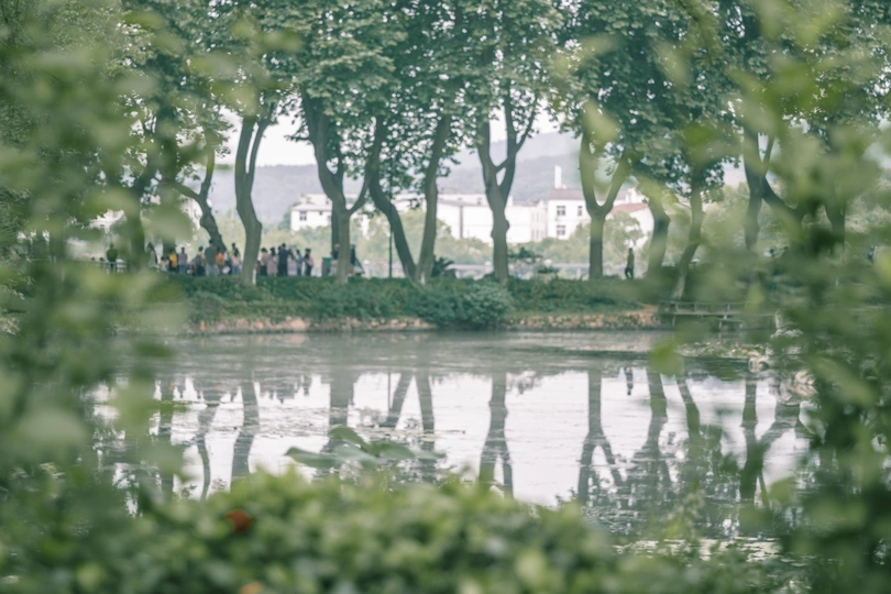 人们在池塘旁的公园里散步