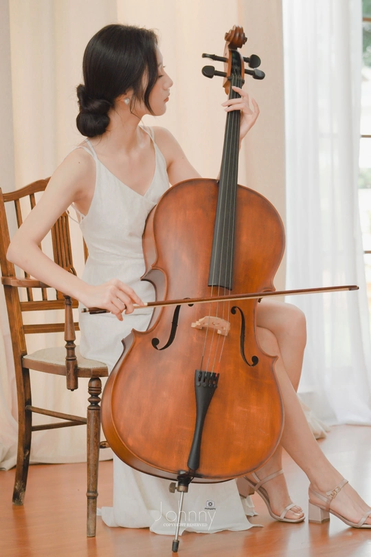 坐在椅子上的拿着大提琴的年轻女子