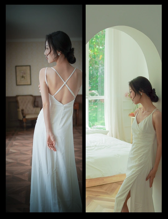 一个穿着白色连衣裙的女人站在窗前