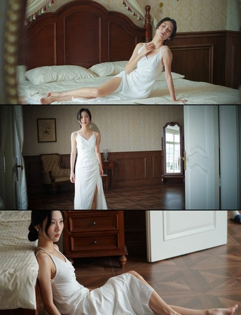 一个穿着白色连衣裙的女人躺在卧室的床上