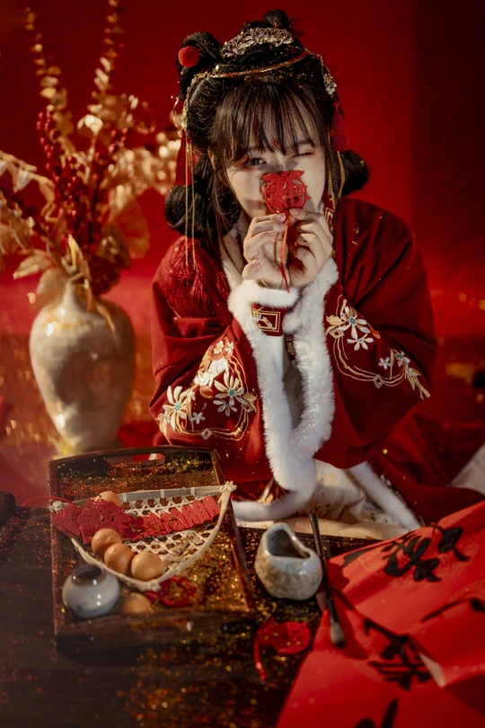一位穿着红色服装的年轻女子坐在桌子旁