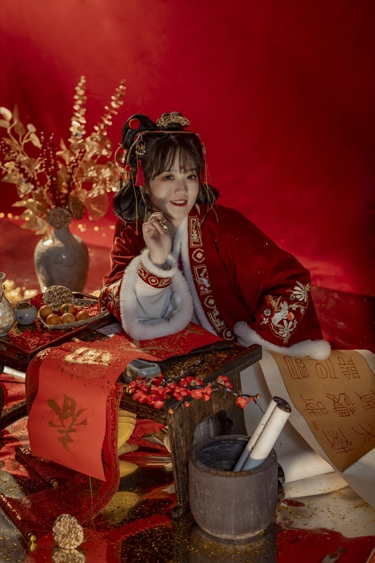 一张年轻女孩穿着红裙坐在礼物前面的照片