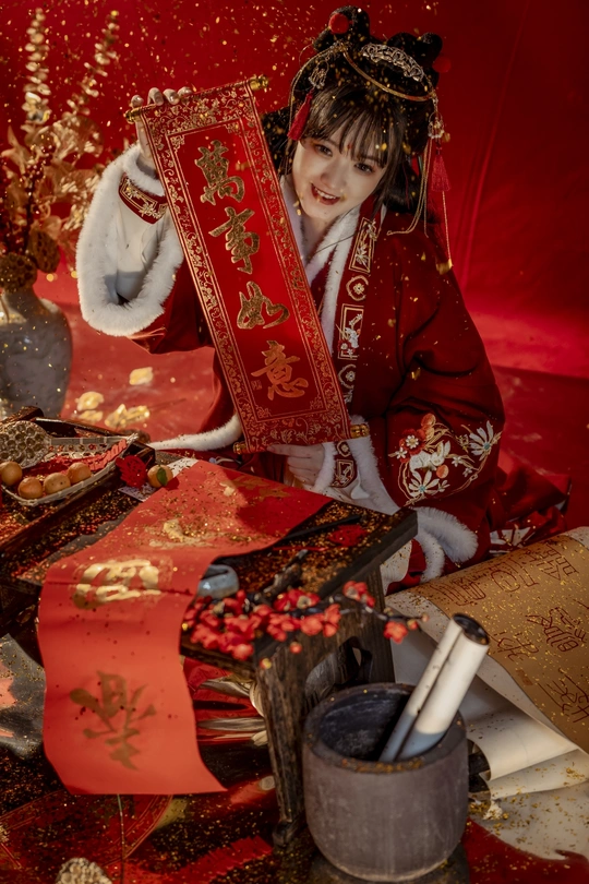 一位穿着传统红色和服的年轻女子正在拆礼物。