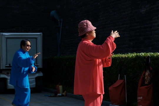 一位穿着红袍子的女人站在一位男士旁边