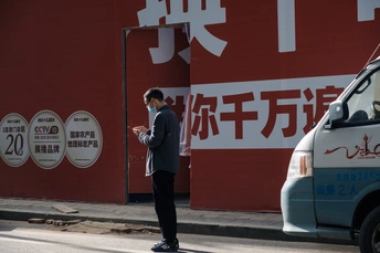 一位戴口罩的男子在中国武汉市的街道上行走 随着新冠病毒疫情的蔓延 这张照片记录了该市迅速扩大的情景。
